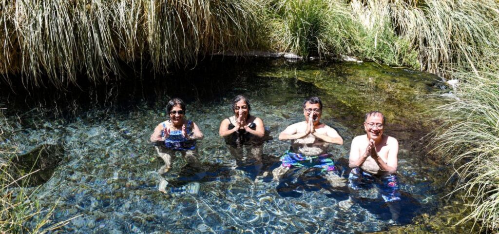 Personas sumergiddas en las aguas termales de las termas de puritama en san pedro de atacama